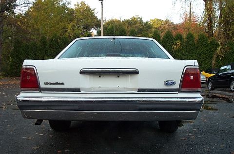 1991 Ford LTD Crown Victoria - Rear view of a white 1991 Ford Crown Victoria LTD parked outdoors with trees in the background.