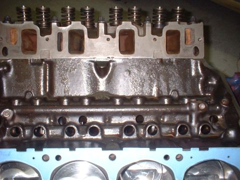 1957 Ford Custom Sedan - Close-up view of an engine block and cylinder head, showing valve springs and intake ports.
