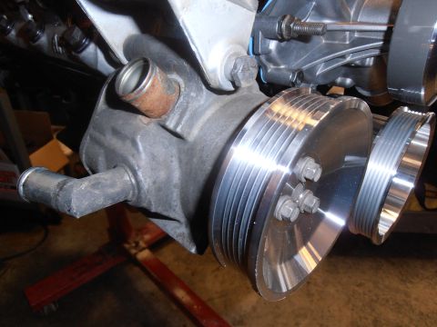 1990 Ford Bronco - Close-up view of engine components, including polished pulleys and a corroded hose fitting.