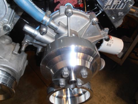 1990 Ford Bronco - Engine water pump and pulley assembly with a blue hose and oil filter attached.