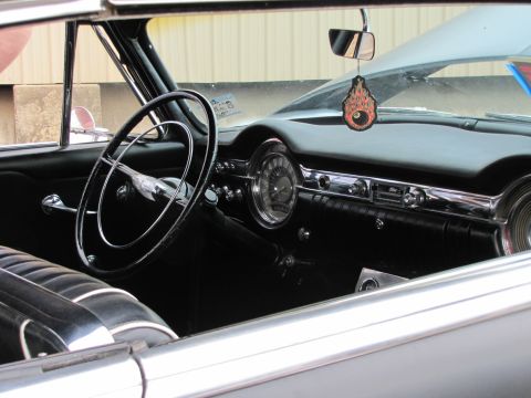 2006 BMW 5 Series - The interior of a classic car shows a large steering wheel and a dashboard with chrome accents.