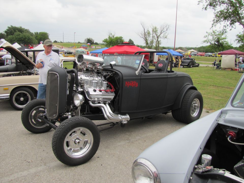 Black hot rod with exposed engine and "Nasty" text on the side