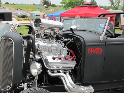 2006 BMW 5 Series - Custom hot rod features a prominent supercharger and side pipes at an outdoor car show.