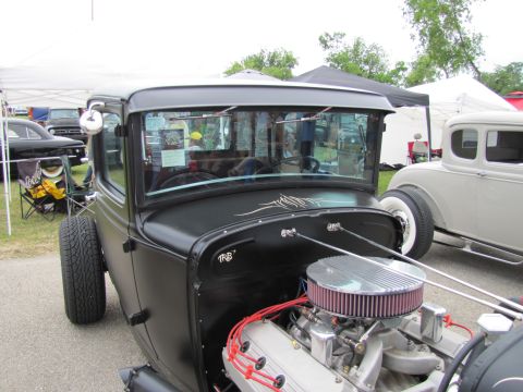 2006 BMW 5 Series - A custom hot rod with a powerful engine is displayed at an outdoor event.
