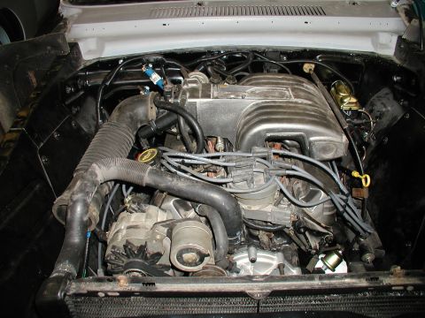 1960 Ford Ranchero - Close-up view of a V8 engine bay, the intake manifold, air intake system, and alternator.