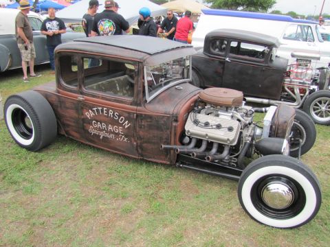 2006 BMW 5 Series - A heavily customized rat rod with a prominent engine and vintage signage is displayed outdoors.