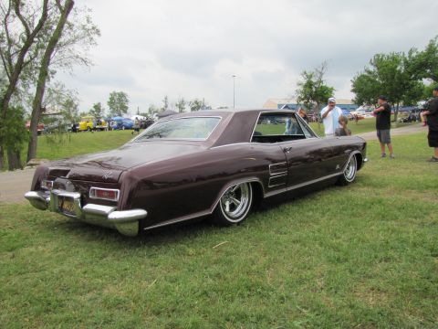 2006 BMW 5 Series - A classic 1966 Buick Riviera is displayed at an outdoor event with other vehicles in the background.