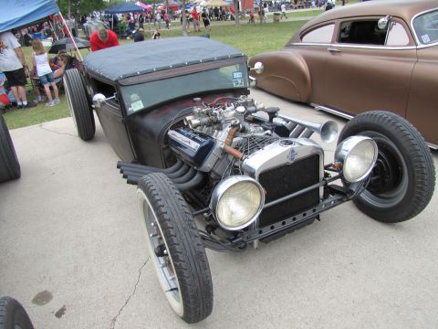 2006 BMW 5 Series - A custom hot rod with a powerful engine and unique exhaust system is displayed at an outdoor event.