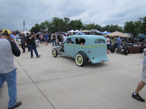 2006 BMW 5 Series - A light blue hot rod sedan is parked at an outdoor car show with spectators around.
