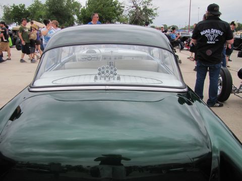 2006 BMW 5 Series - View of a classic green car's interior from the rear, showing white seats and a decorative element on the back dash.