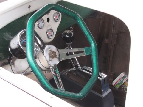 2006 BMW 5 Series - The interior of a custom vehicle features a sparkly green steering wheel and a dashboard with multiple gauges.