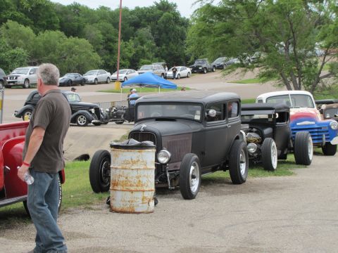 2006 BMW 5 Series - A line of hot rod vehicles are parked at an outdoor event.