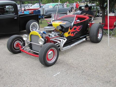2006 BMW 5 Series - Custom hot rod roadster displayed at an outdoor car show with other vehicles in the background.