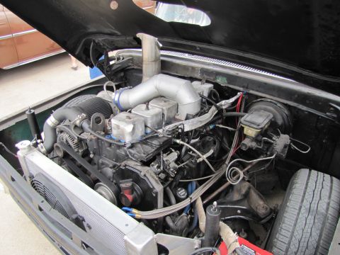 2006 BMW 5 Series - Custom engine bay features a large turbocharger and extensive intercooler piping, suggesting significant performance modifications.
