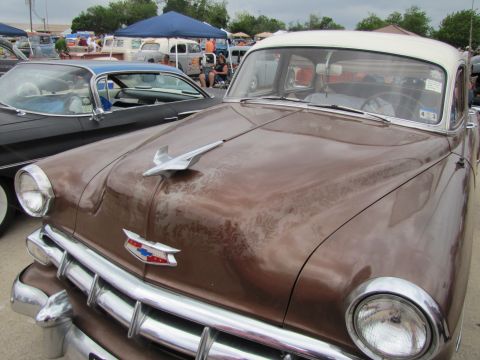 2006 BMW 5 Series - Front view of a weathered brown 1950s Chevrolet sedan at an outdoor car show.