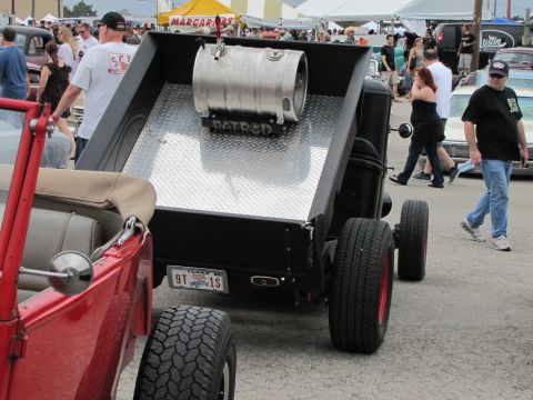 2006 BMW 5 Series - A custom truck with a keg in the bed is parked next to a red convertible at an outdoor event.