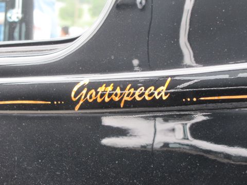 2006 BMW 5 Series - A custom script reads 'Gottspeed' on the side of a dark-colored vehicle, accented with orange lines.