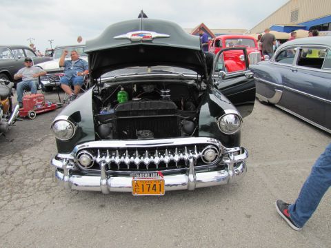 2006 BMW 5 Series - Classic Chevrolet with open hood and custom engine decoration at a car show.