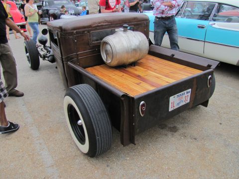 2006 BMW 5 Series - A custom pickup truck with a keg in the bed is parked next to a classic car.