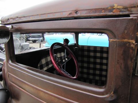 2006 BMW 5 Series - View through the window of a vintage truck's interior, with other vehicles visible in the background.