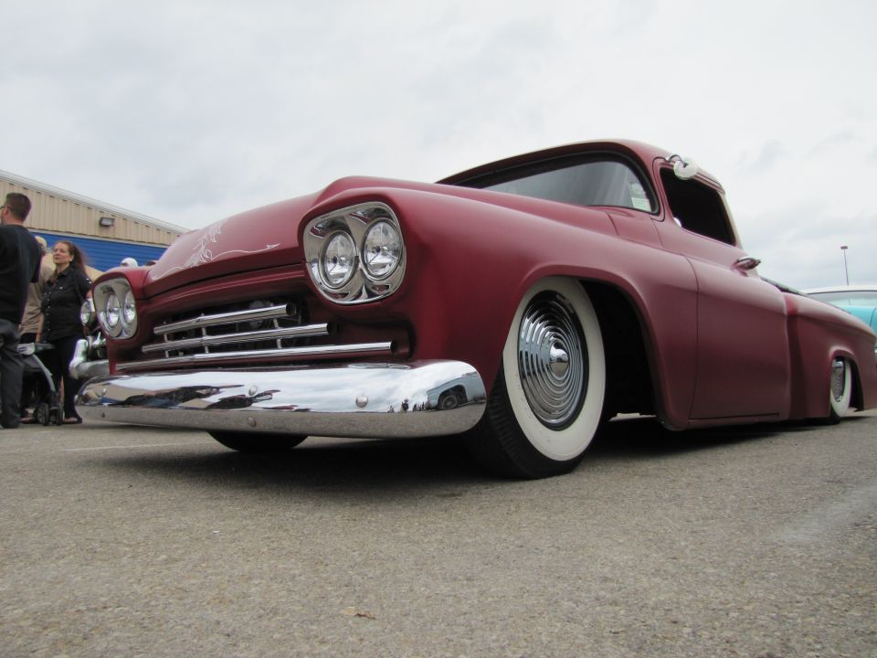 Red pickup truck front view, whitewall tires, chrome bumper, lowered suspension