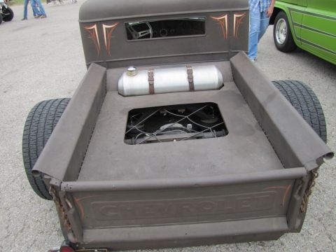 2006 BMW 5 Series - A custom rat rod pickup truck is viewed from the rear, showing its modified bed and exposed mechanical components.