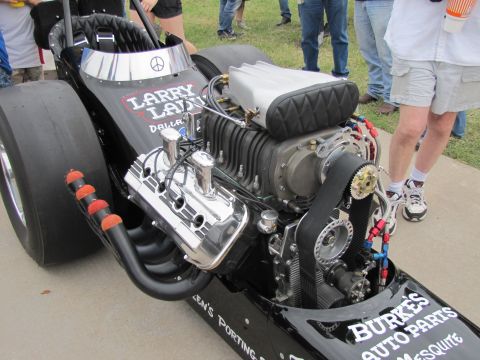 2006 BMW 5 Series - A powerful dragster engine with a prominent supercharger and exhaust pipes is displayed outdoors.
