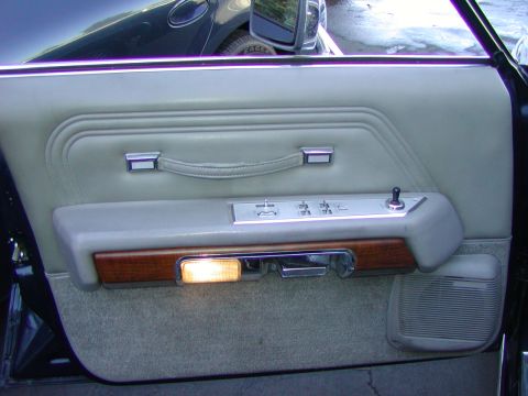 1991 Ford LTD Crown Victoria - Close-up of a car's interior door panel, showing the window controls and a illuminated interior light.