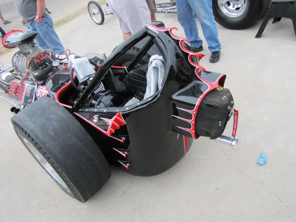 Black dragster with red flame graphics and a large rear tire