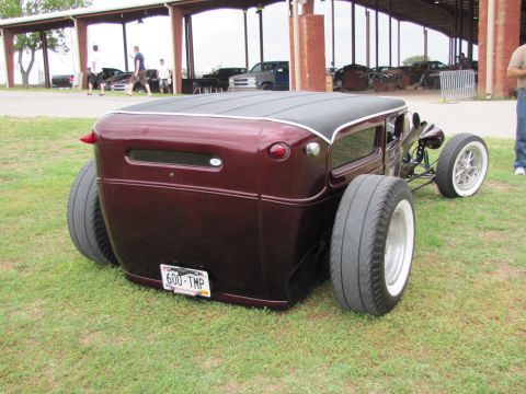 2006 BMW 5 Series - This custom hot rod features a maroon paint job, wide rear tires, and whitewall front tires, parked on grass.