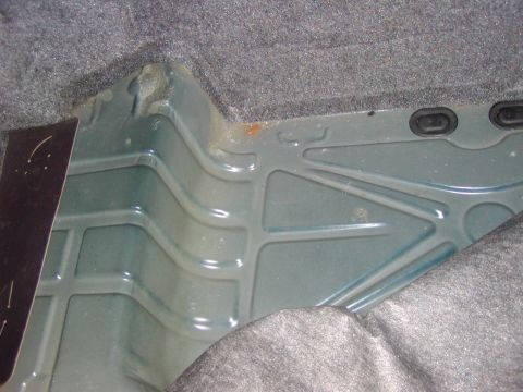 1991 Ford LTD Crown Victoria - Close-up view of the interior of a car's trunk, showing the metal floor pan and carpet lining.