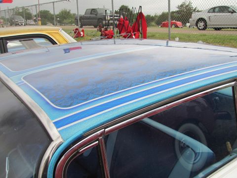 2006 BMW 5 Series - A car roof features intricate blue pinstriping and a reflection of the Texas flag, with other vehicles visible in the background.