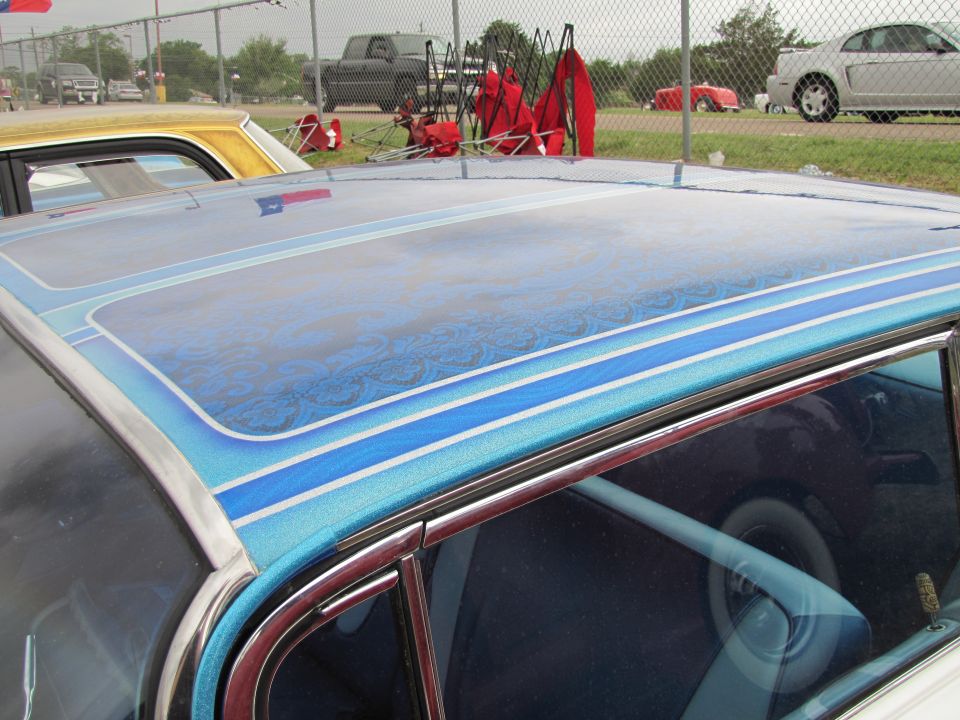 Blue custom painted car roof with pinstripes and a Texas flag reflection