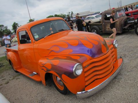 2006 BMW 5 Series - Customized vintage pickup truck with flame graphics at an outdoor car show.
