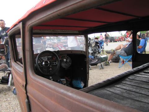 2006 BMW 5 Series - Interior view of a weathered rat rod with people and other vehicles in the background.