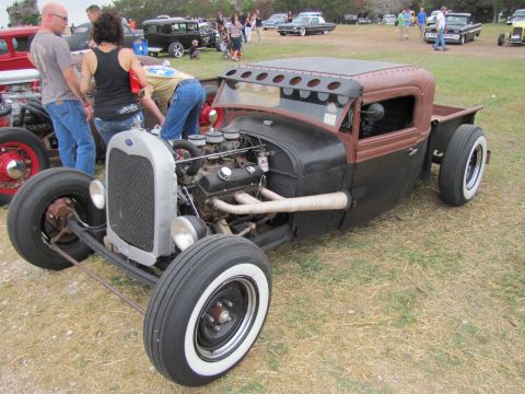 2006 BMW 5 Series - A custom hot rod pickup truck is displayed outdoors with several people looking at it.