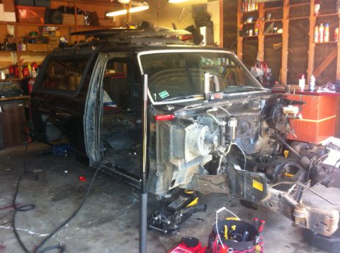 1989 Ford Bronco - This 1989 Ford Bronco is in a state of disassembly, likely for a tub swap or other significant repair work within a garage setting.