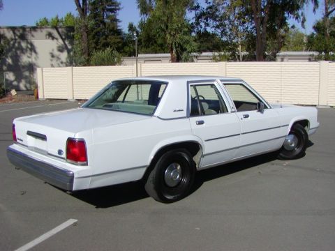 1991 Ford LTD Crown Victoria - This white 1991 Ford Crown Victoria LTD sedan is shown from a three-quarter front perspective.