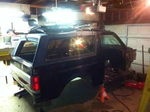 1989 Ford Bronco - Ford Bronco body undergoing work in a garage, front end is disassembled.