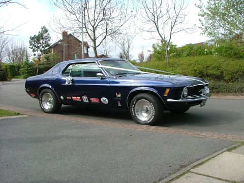 1970 Ford Mustang - A dark blue 1970 Ford Mustang is decorated with a white ribbon and racing decals.