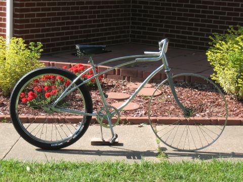 1994 Ford Bronco - A custom cruiser bicycle is parked on a sidewalk in front of a brick building.
