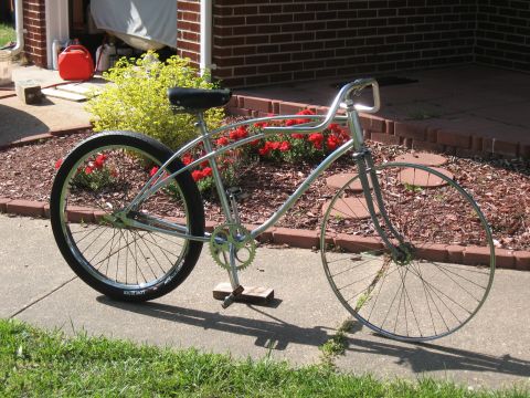 1994 Ford Bronco - A silver cruiser bicycle with a black seat and wide tires is parked on a sidewalk.