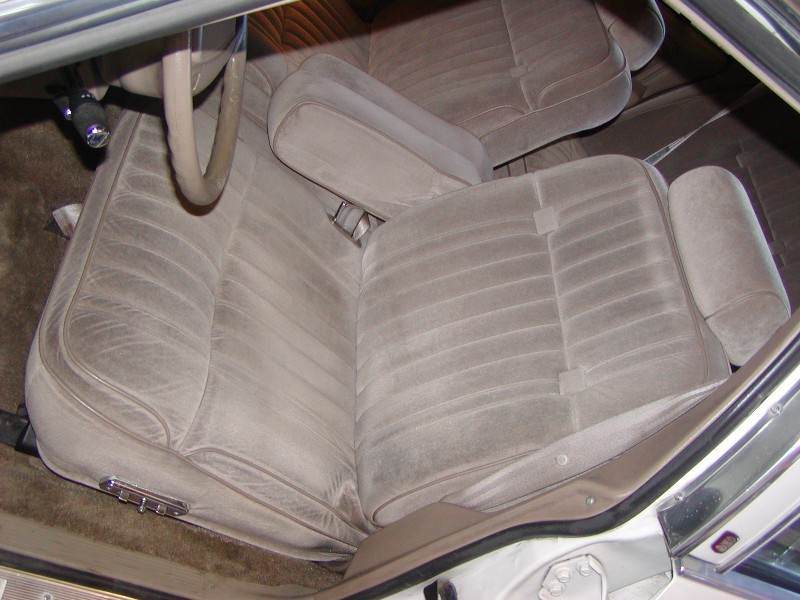 Interior view of a car showing front velour seats and steering wheel