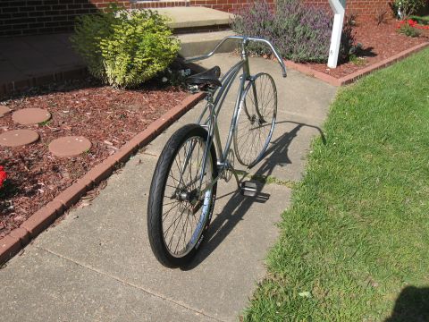 1994 Ford Bronco - A vintage bicycle with chrome accents is parked on a concrete path next to a lawn and garden bed.