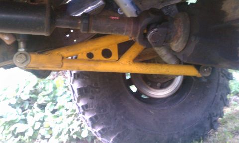 1978 Ford Bronco - Close-up view of a vehicle's undercarriage, focusing on suspension components and a tire.