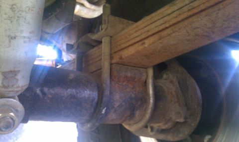 1978 Ford Bronco - Close-up view of the rear axle and leaf spring suspension system on a vehicle.