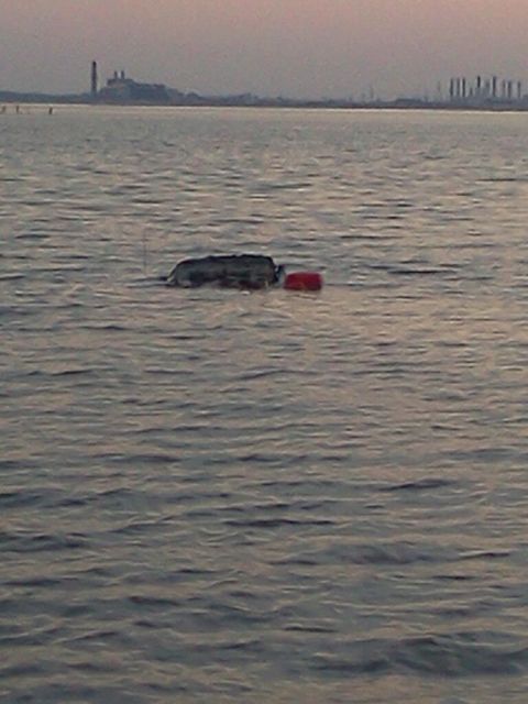 1990 Ford Bronco - A vehicle is partially submerged in the water with a red buoy nearby.
