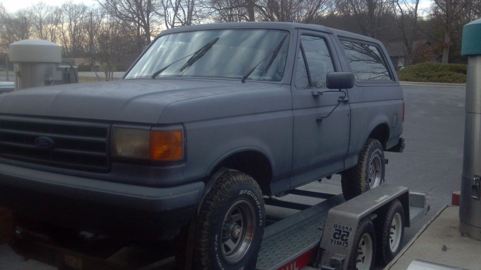 Gray 1987 Ford Bronco on a trailer, front 3/4 view
