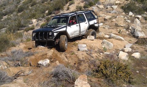 1978 Ford Bronco - Modified Jeep Cherokee XJ navigating a challenging rocky off-road trail.