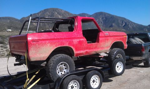 1978 Ford Bronco - 1978 Ford Bronco with custom roll cage loaded onto a trailer.